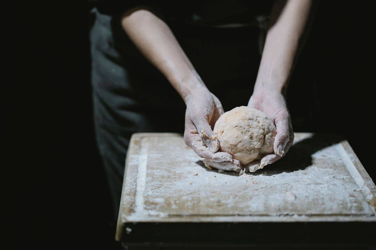 Hands kneading dough in the kitchen